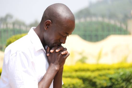 A black man glorifying God in prayer. A black man glorifying God in prayer.