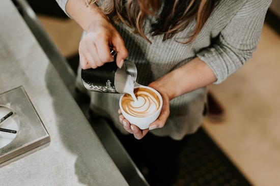 Barista preparing a latte in a coffee shop Going to a coffee shop is one way to reward yourself. It can feel special when watching a barista prepare a latte.