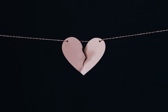 Paper heart in pink torn in two, tied to a rope, as we learn how sin is a failure to love God and love others.