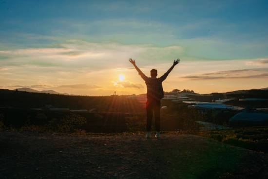 The image of a man raising his arms as He faces the setting sun shows that at the Second Coming, those who look forward to Jesus' return will be filled with joy and celebration.