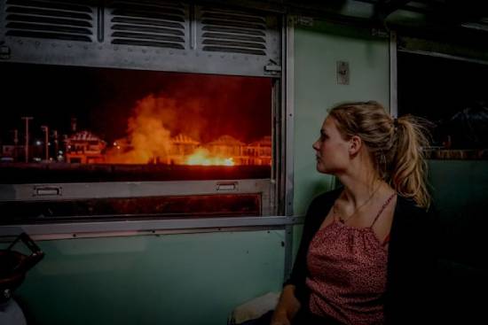 The image of a woman watching a fire blazing at houses across the street demonstrates the disasters on Earth that lead up to Christ's return. It reminds us to watch for Jesus, and that His return will be visible to all.