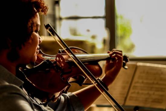 woman playing a violin A woman plays a violin, an instrument known to make beautiful music.